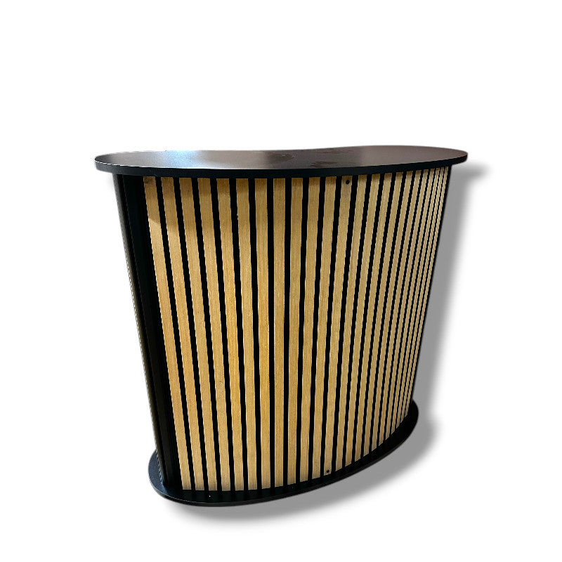 Bøygd diskur við hylldu. Forsíða við akustikplátu / trælamellum. B104 x D43 x H105 cm.